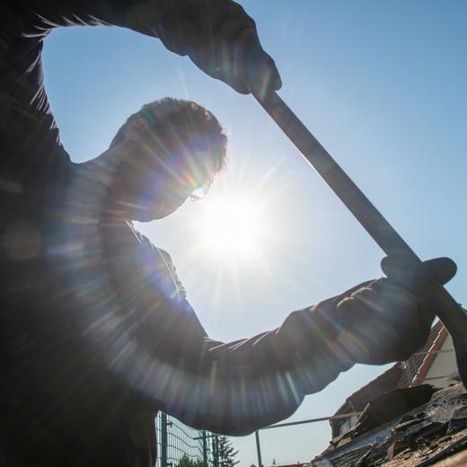 dpatopbilder - 26.06.2019, Sachsen-Anhalt, Burg: Ein Dachdecker von der Firma Fischer-Bedachungen entfernt am frühen Morgen bei wolkenlosem Himmel Schindeln aus Bitumen von einem Dach. Angesichts der hohen Temperaturen verlegen viele Dachdecker ihre Arbeitszeit derzeit in den Morgen, um so der Hitze aus dem weg zu gehen. Im Landkreis Jerichower Land wird der bisher wärmste Tag des Jahres erwartet. Laut Meteorologen steigen die Temperaturen bei praller Sonne bis zu 37 Grad Celsius. Foto: Klaus-Dietmar Gabbert/dpa-Zentralbid/dpa +++ dpa-Bildfunk +++ (KEYSTONE/DPA/Klaus-Dietmar Gabbert)