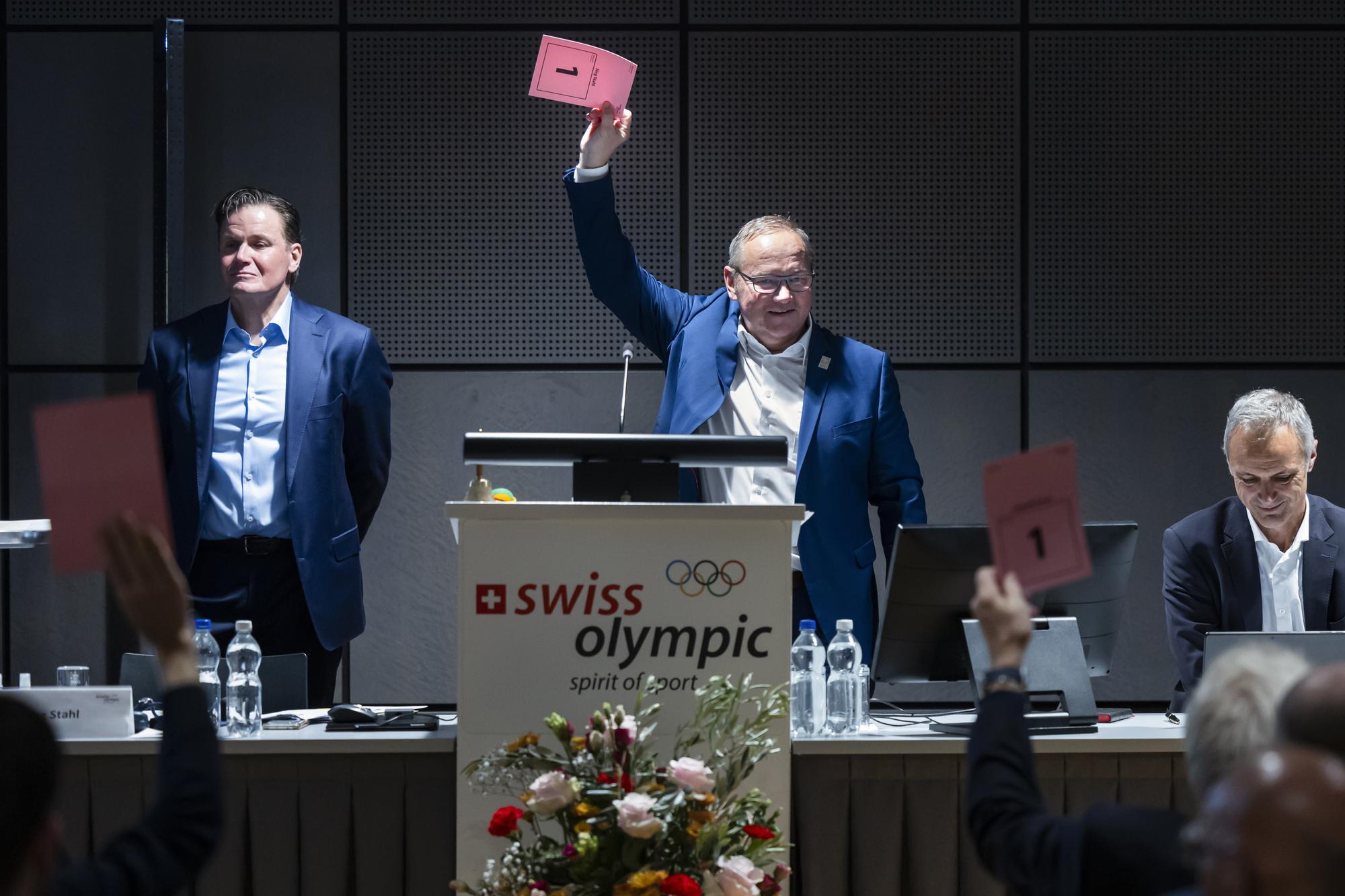 Swiss Olympic Praesident Juerg Stahl, Mitte, Urs Lehmann, Praesident Swiss-Ski, links, und Roger Schnegg, Direktor Swiss Olympic, rechts, bei der Abstimmung um Olympische und Paralympische Winterspiele "Switzerland 203x" bei der 27. Versammlung des Sportparlaments von Swiss Olympic, am Freitag, 24. November 2023, im Haus des Sports in Ittigen. (KEYSTONE/Peter Klaunzer)