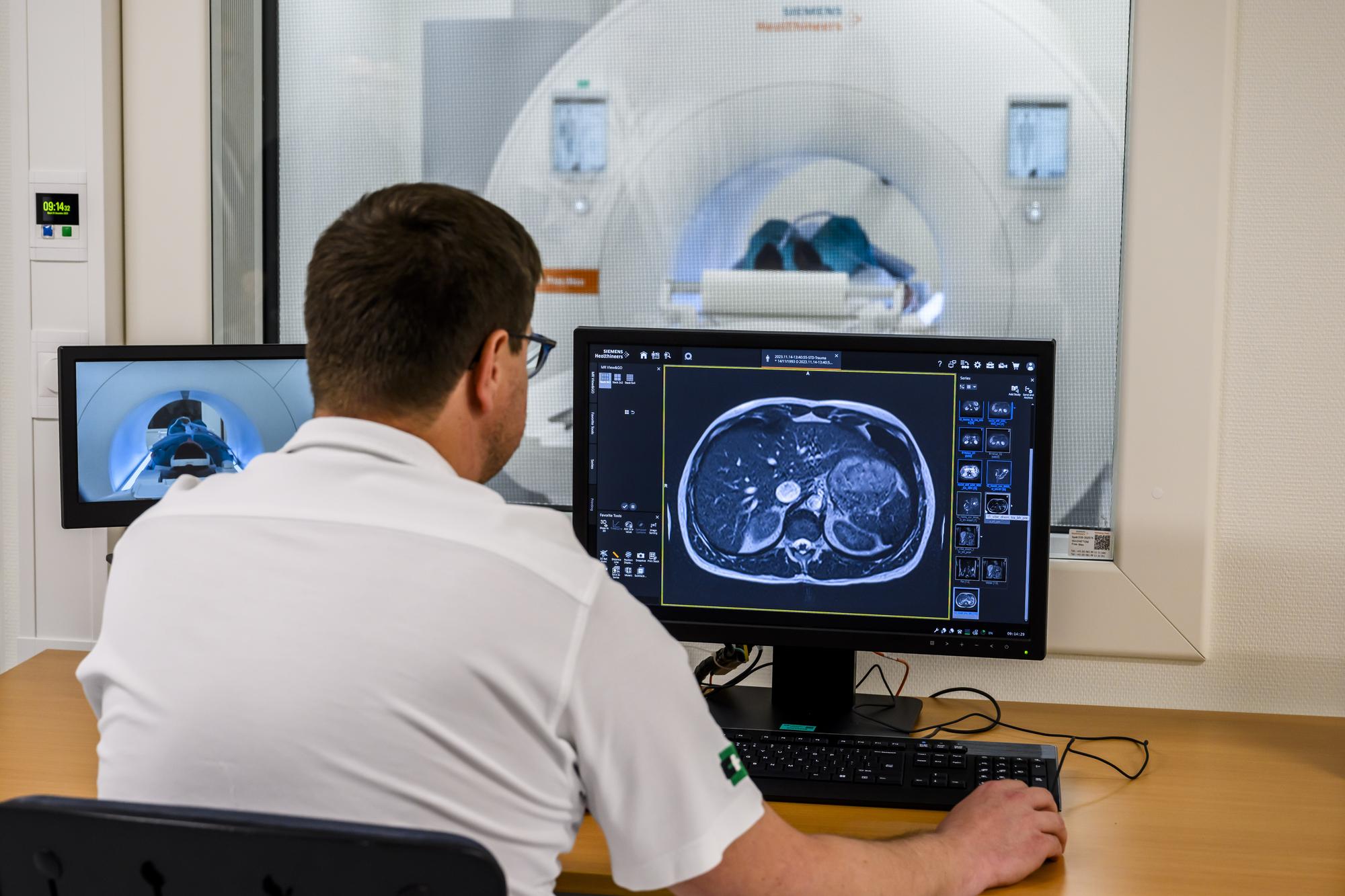 Jean-Baptiste Ledoux, technicien en radiologie medicale du CHUV, controle son ordinateur lors d'un examen fictif avec patiente fictive et le nouvel appareil IRM plus economique et durable le mardi 5 decembre 2023 au CHUV a Lausanne. Le CHUV se dote d?un appareil a imagerie par resonance magnetique (IRM Low field) a bas champ de nouvelle generation, assiste par l'intelligence artificielle. (KEYSTONE/Jean-Christophe Bott)