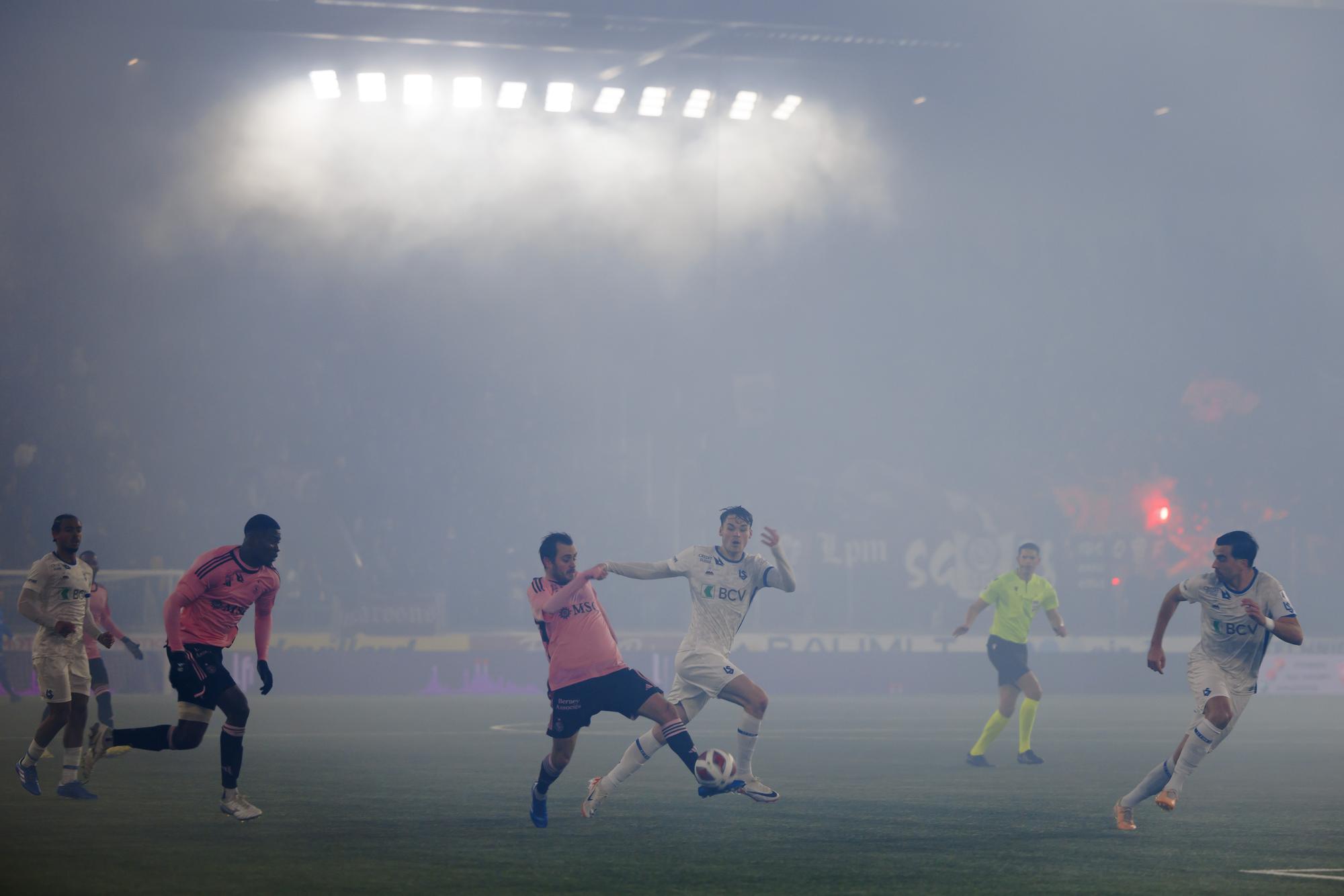 Le milieu genevois Timothe Cognat, gauche, lutte pour le ballon avec le milieu lausannois Jamie Roche, droite, lors de la rencontre de football de Super League entre le FC Lausanne-Sport, LS, et le Servette FC, SFC, ce samedi 9 decembre 2023 au stade de la Tuiliere a Lausanne. (KEYSTONE/Valentin Flauraud)