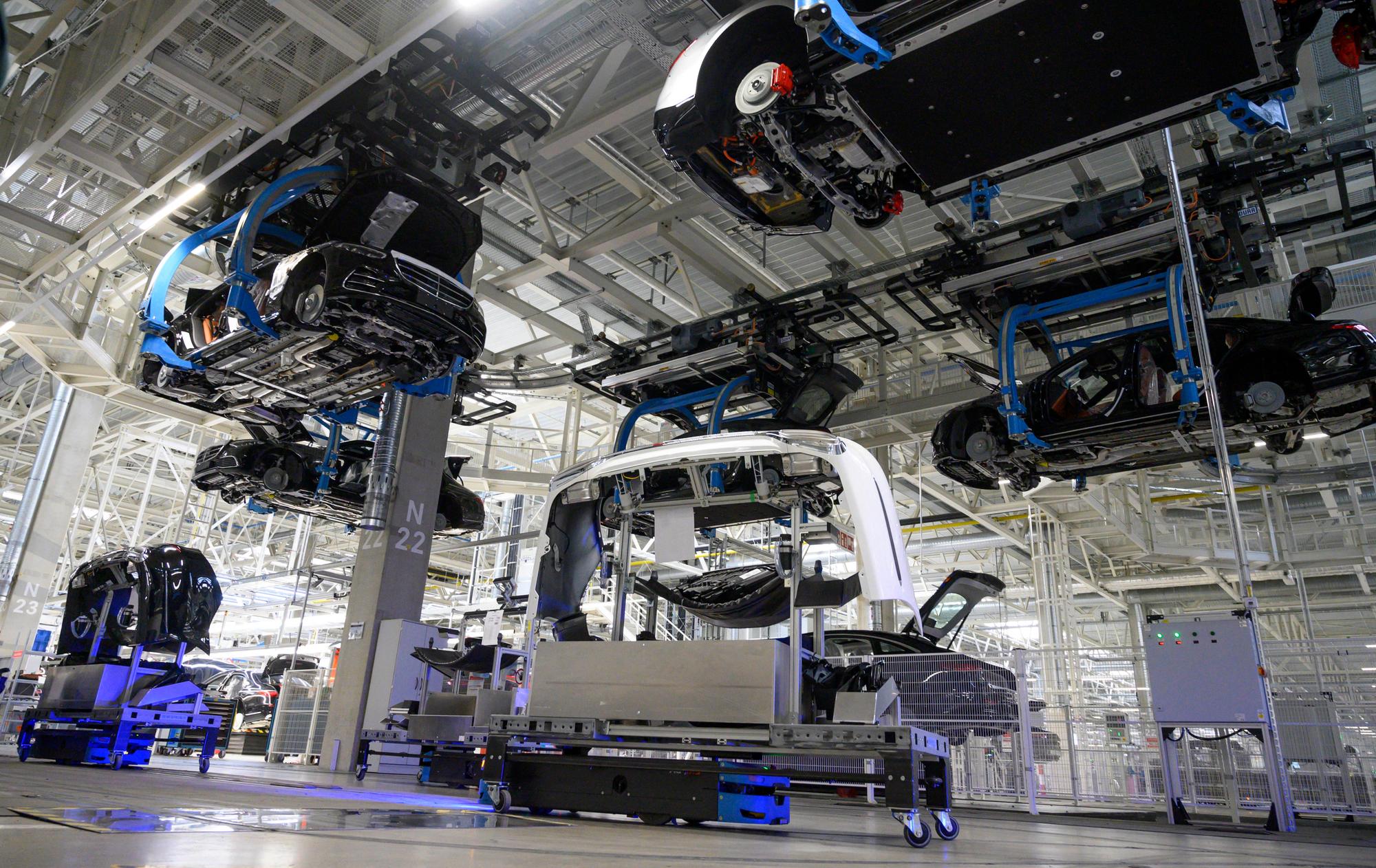 Mercedes-Benz EQS and S-Class passenger cars are transported automatically to their next production step while on the ground automatic vehicles transport body components at the 'Factory 56', a completely digitized assembly line, at the Mercedes-Benz manufacturing plant in Sindelfingen, southwestern Germany, on February 13, 2023. Mercedes-Benz will present their 2022 annual results on February 17, 2023. (Photo by THOMAS KIENZLE / AFP)