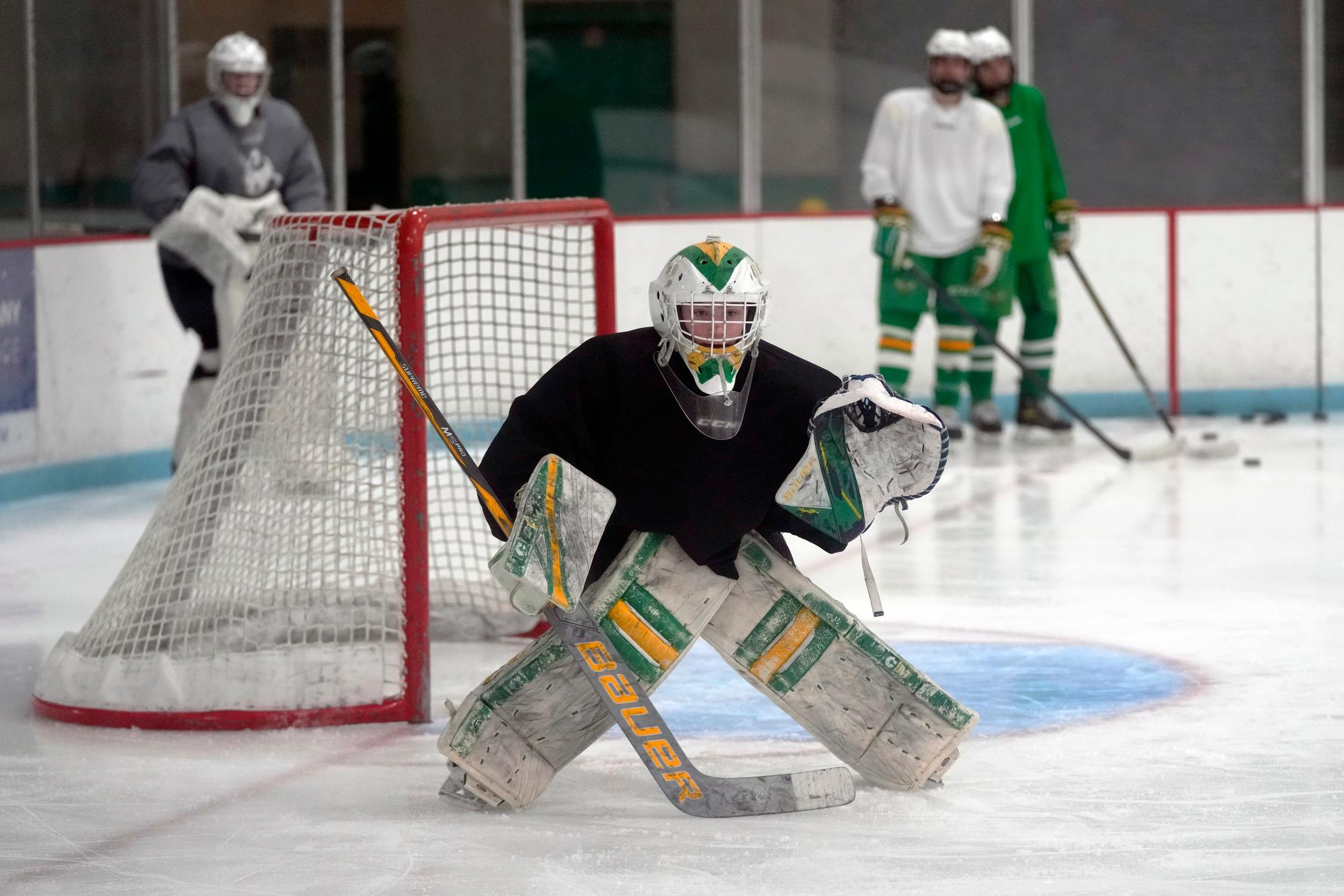 Evan Smolik prepares to stop a shot during a hockey practice Wednesday, Nov. 29, 2023, in Edina, Minn. When Evan was 14, a teammate's skate struck his neck and his jugular vein, but the neck guard he was wearing prevented the skate from cutting his carotid artery and helped save his life. (AP Photo/Abbie Parr)