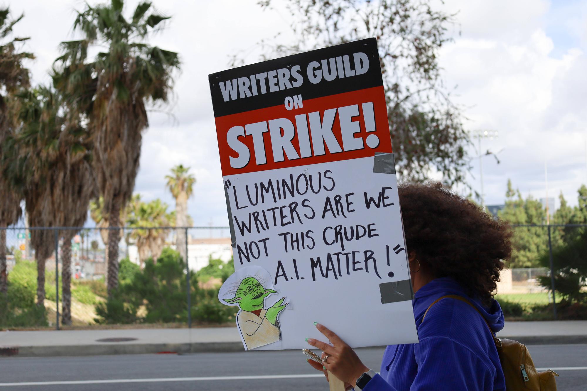 May 4, 2023, Hollywood, California, U.S: Stiking woman holds ÃƒÃ¢oeWriters Guild on Strike: Luminous Writers are not this crude A.I MatterÃƒÃ¢Ã‚ Sign. ..Picketers in front of Netflix Sunset Studios in Hollywood on May 4, 2023 in support of Writers Guild of America WritersÃƒÃ¢Ã¢ Strike on May 4, 2023 ÃƒÃ¢ day 3 of the first WriterÃƒÃ¢Ã¢ s strike in 15 years. Thousands of writers and others in the film and TV industry carried signs on the picket lines in front of Los Angeles/Hollywood studios to demand more pay, controls on AI and better work conditions. Hollywood U.S. - ZUMAk144 20230504_znp_k144_080 Copyright: xAmyxKatzx