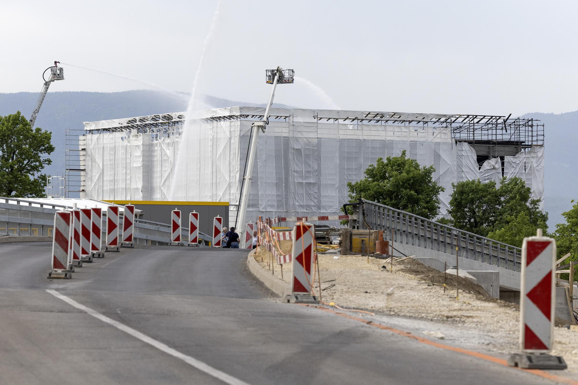Les pompiers du Service d'incendie et de secours (SIS) interviennent sur le feu de chantier du futur centre federal de requerants d'asile situe pres du bout de la piste de Geneve Aeroport, ce vendredi 20 mai 2022 a Geneve. Un gros incendie a eclate vendredi, en fin d'apres-midi, a proximite de l'aeroport de Geneve. Selon le porte-parole du Service incendie et secours (SIS) le feu a pris sur le chantier du futur centre federal de requerants d'asile. Les pompiers ont deploye d'importants moyens. (KEYSTONE/Salvatore Di Nolfi)