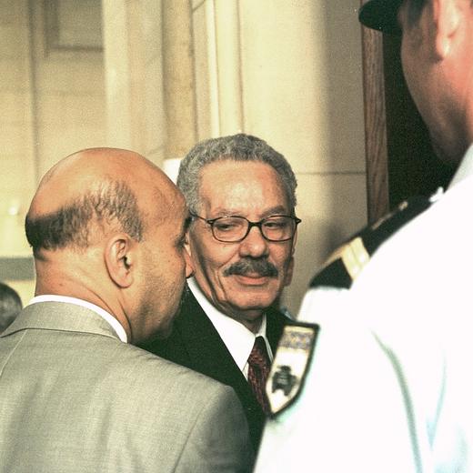 Fomer Algerian defense Minister and retired General Khaled Nezzar, center, looks at an unidentified man as he enters the district court at the Paris courthouse Monday July 1, 2002. Nezzar has sued Habib Souaidia, a former army officer and best-selling author for defamation for linking him to atrocities in Algeria's war on islamic extremists. (AP Photo/Amel Pain)
