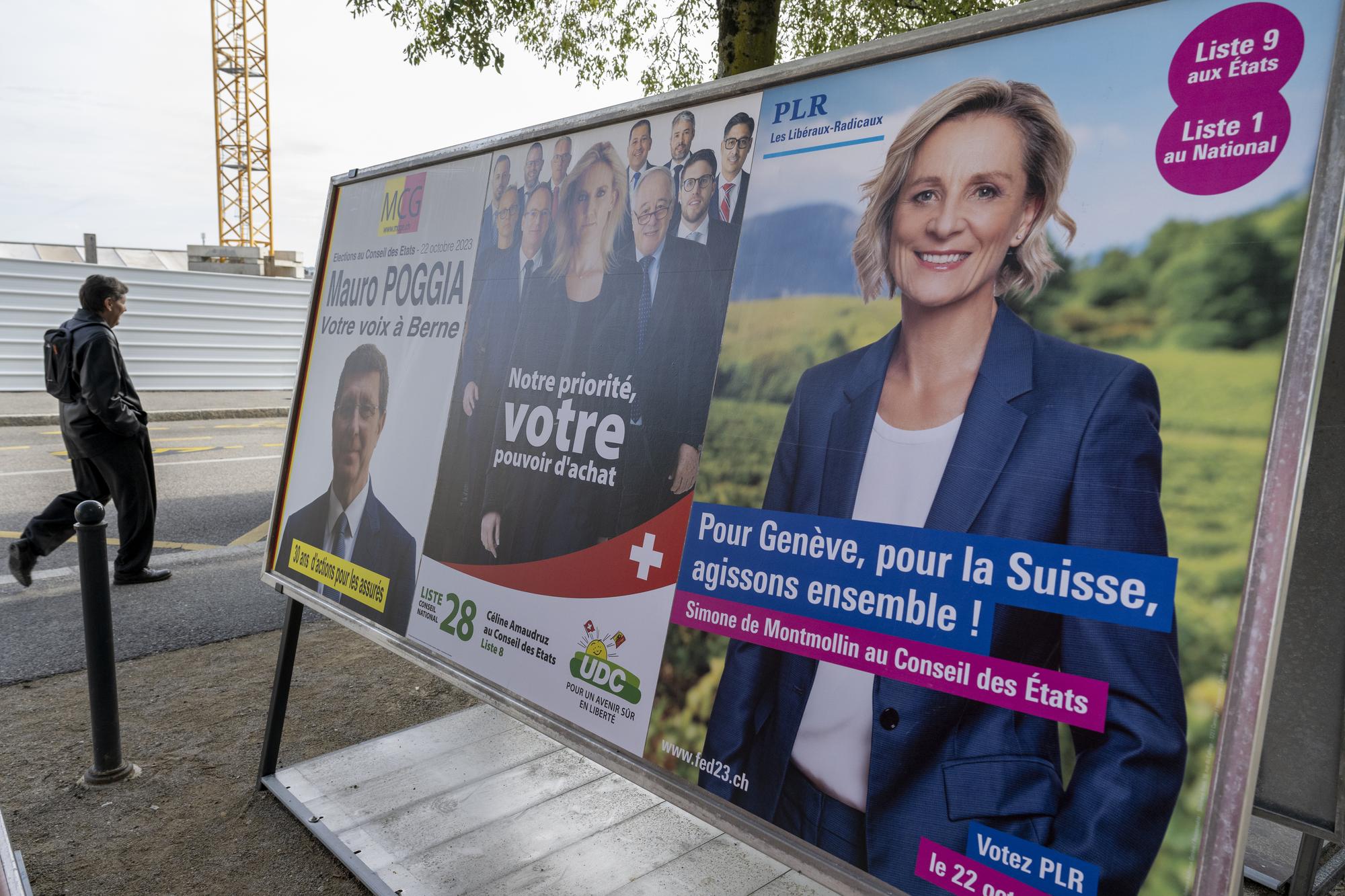 Une personne passe devant les affiches electorales pour les candidats au conseil national et au Conseil des Etats, de gauche a droite, Mauro Poggia MCG, Celine Amaudruz UDC et Simone de Montmollin PLR, lors la campagne pour les elections federales ce jeudi 28 septembre 2023 a Geneve. Les prochaines elections federales (elections du Conseil national et du Conseil des Etats) auront lieu le 22 octobre 2023. (KEYSTONE/Martial Trezzini)