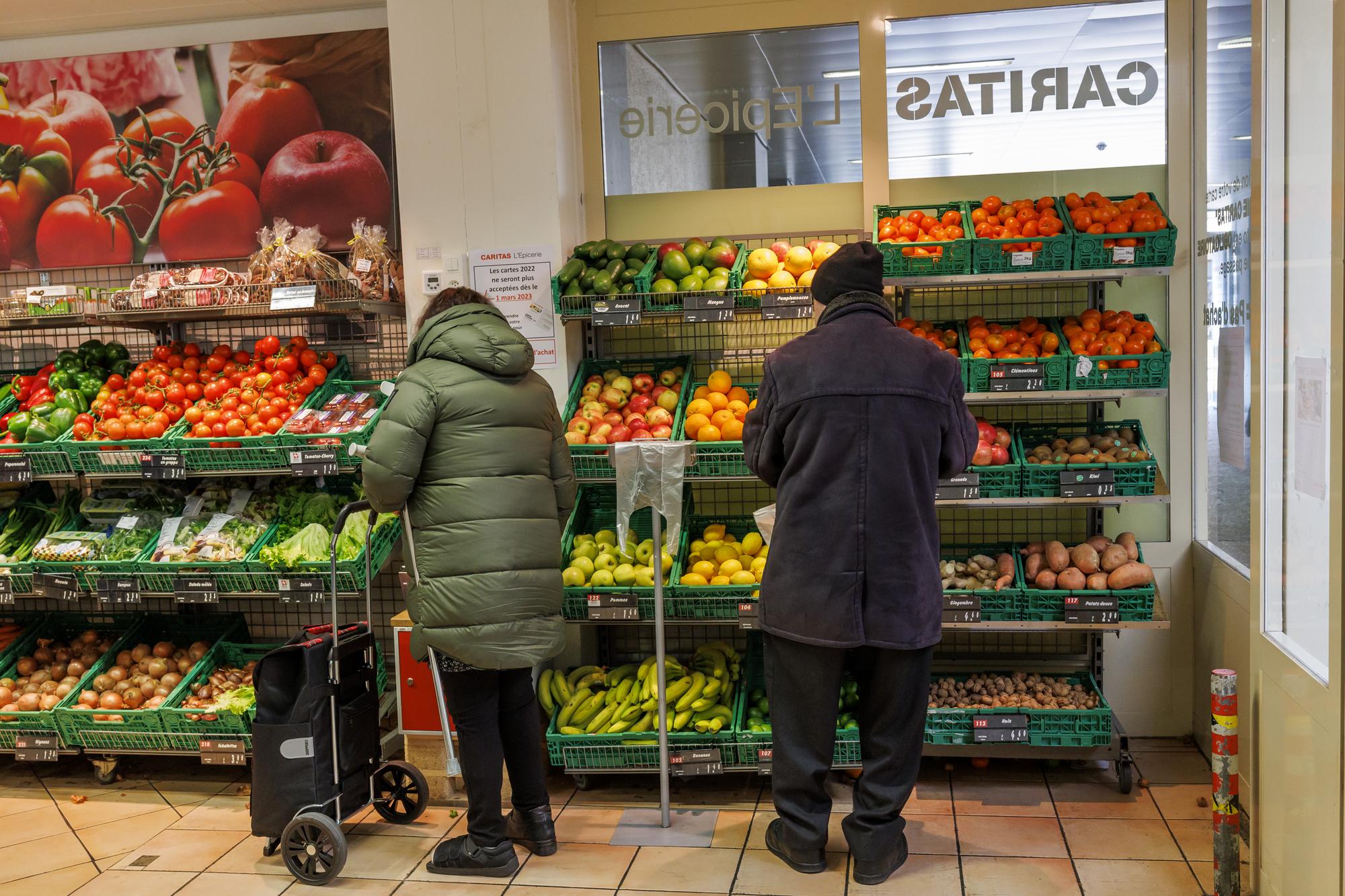 Des personnes font leurs achats à l'épicerie de la rue de Carouge, en février 2023.