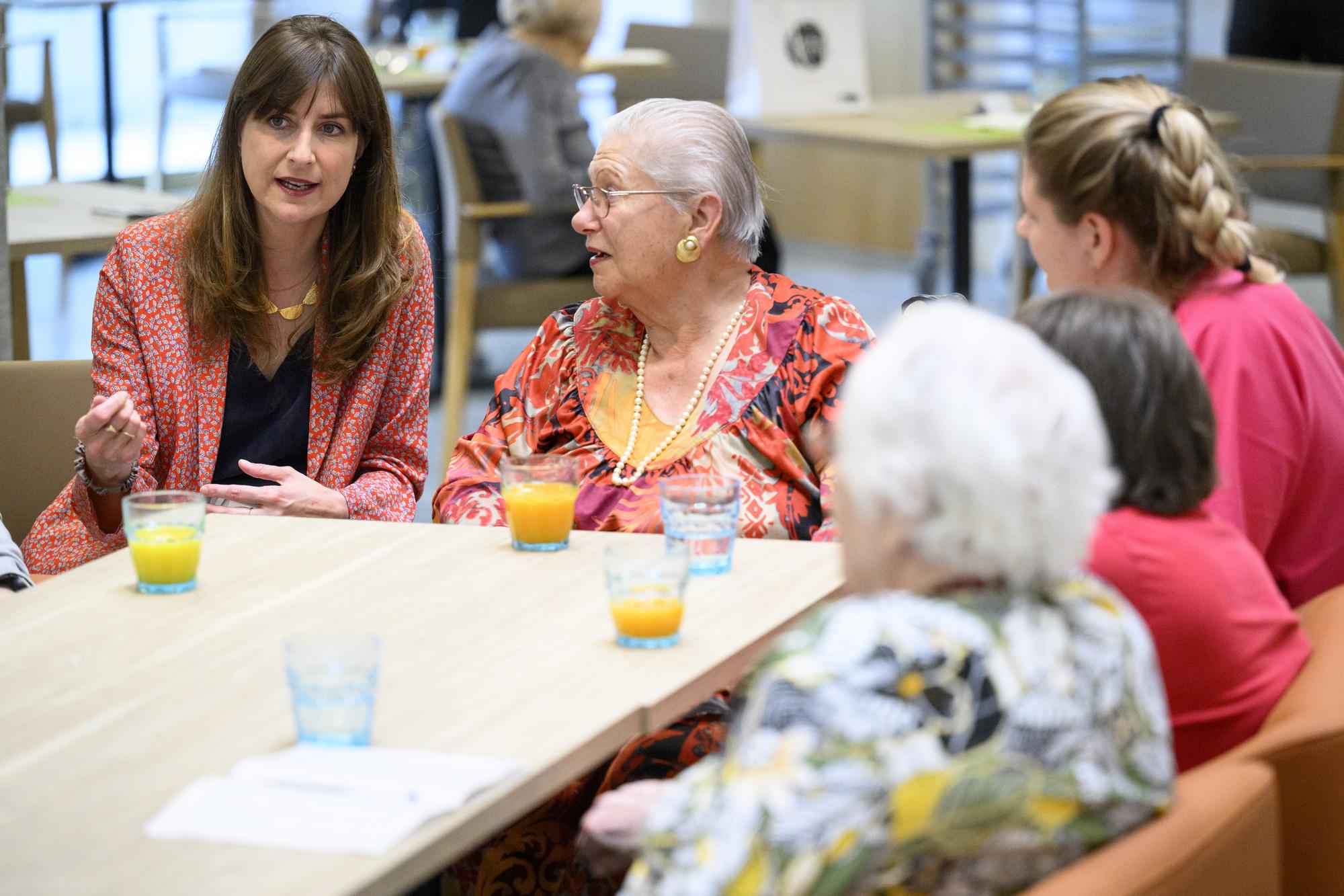 La conseillere d'Etat vaudoise Rebecca Ruiz, gauche, parle avec des personnes agees residantes en EMS avant une conference de presse sur l'augmentation des lits en EMS dans le canton de vaud ce lundi 19 juin 2023 a l'EMS "Le Tilleul" a Lausanne. Le Canton finance la creation et la renovation de plus de 2360 lits d'etablissements medicosociaux, EMS, et psychosociaux medicalises, EPSM. (KEYSTONE/Laurent Gillieron)