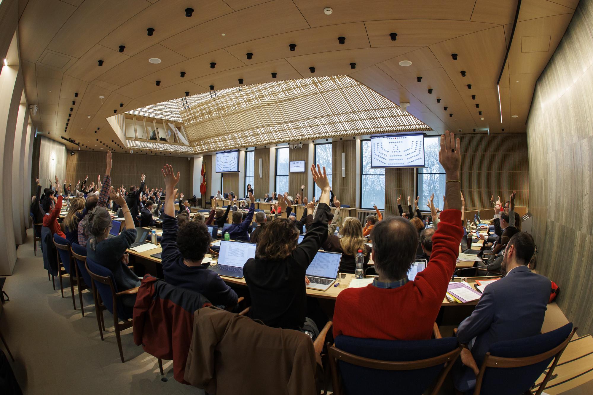 Les deputes votent a mains levees lors d'une session du Grand Conseil genevois, ce vendredi 26 janvier 2024 a Geneve. (KEYSTONE/Salvatore Di Nolfi)