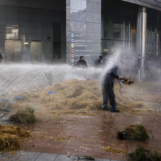 Anti riot police use water to disperse people during a protest by farmers outside the European Parliament as European leaders meet for an EU summit in Brussels, Thursday, Feb. 1, 2024. European Union leaders meet in Brussels for a one day summit to discuss the revision of the Multiannual Financial Framework 2021-2027, including support for Ukraine. (AP Photo/Thomas Padilla)