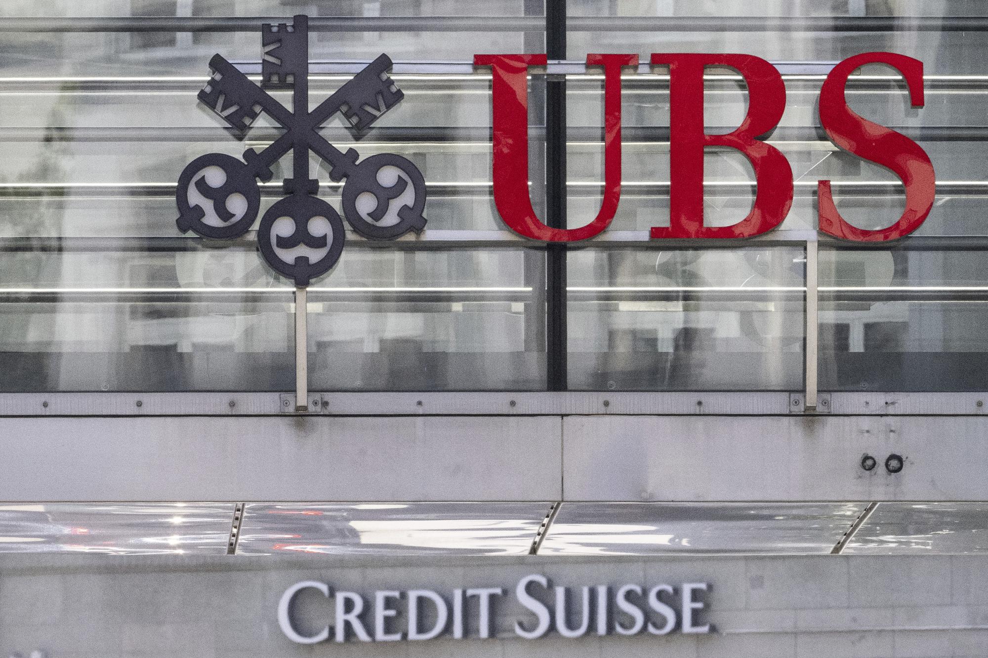 FILE - The logos of the Swiss banks Credit Suisse and UBS are pictured in Zurich, Switzerland, June 12, 2023. UBS on Tuesday, Feb. 6, 2024 reported a fourth-quarter pretax loss of more than $750 million as the Swiss banking giant continued to integrate its longtime rival Credit Suisse after a government-orchestrated merger. (Ennio Leanza/Keystone via AP, File)