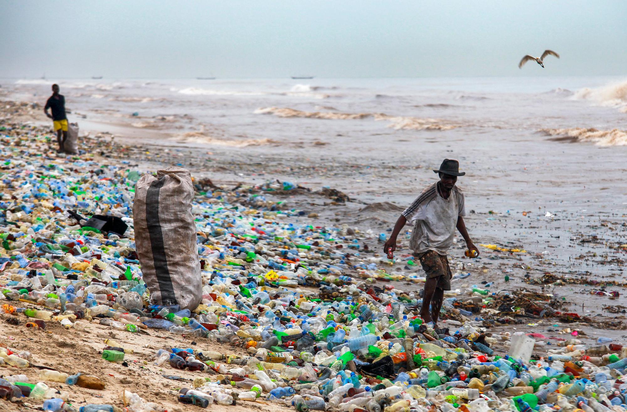 epa05361332 A photograph made availavble 13 June 2016 shows a Ghanaian collecting recyclable material at the polluted Korle Gono beach, that is covered in plastic bottles and other items washed ashore, following weeks of heavy flooding in Accra, Ghana 12 June 2016. The recyclable materials were washed from the capital Accra through the Korle lagoon ending up at the beach. Waste pollution is a continuing problem in Ghana. EPA/CHRISTIAN THOMPSON