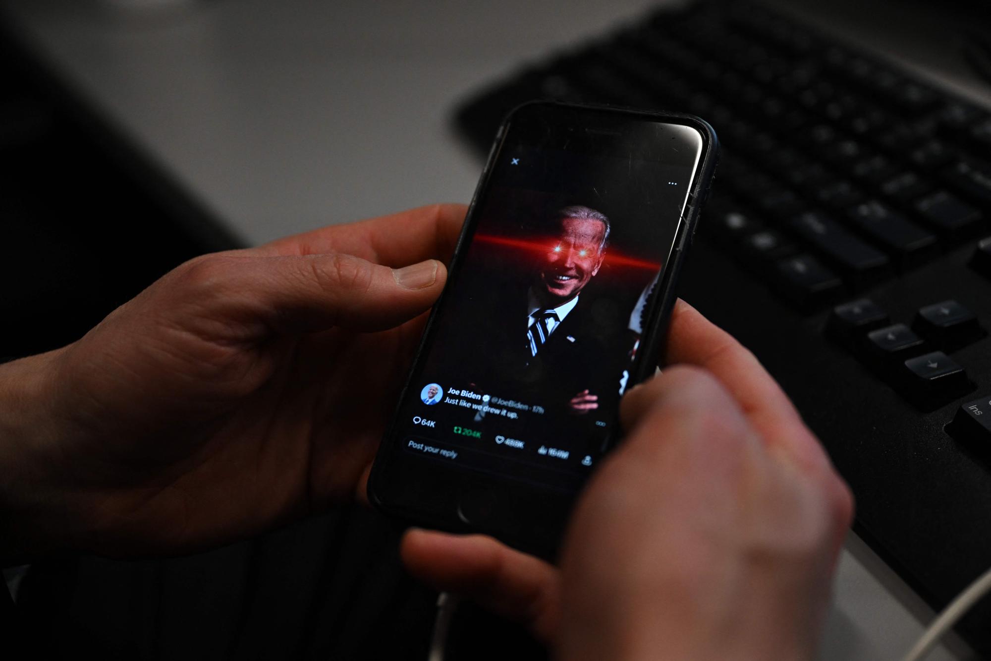 In this photo illustration, a reporter shows US President Joe Biden's X account on their phone at the White House on February 12, 2024 in Washington, DC. US President Joe Biden's debut on TikTok has caused a stir -- not least because the Chinese-owned social media platform is still officially considered a security risk by Washington. The message posted during the Super Bowl on Sunday was part of an effort by the 81-year-old's reelection campaign to reach out to younger voters across social media, including quirky jokes based on a laser-eyed Biden alter-ego. (Photo by Jim WATSON / AFP)