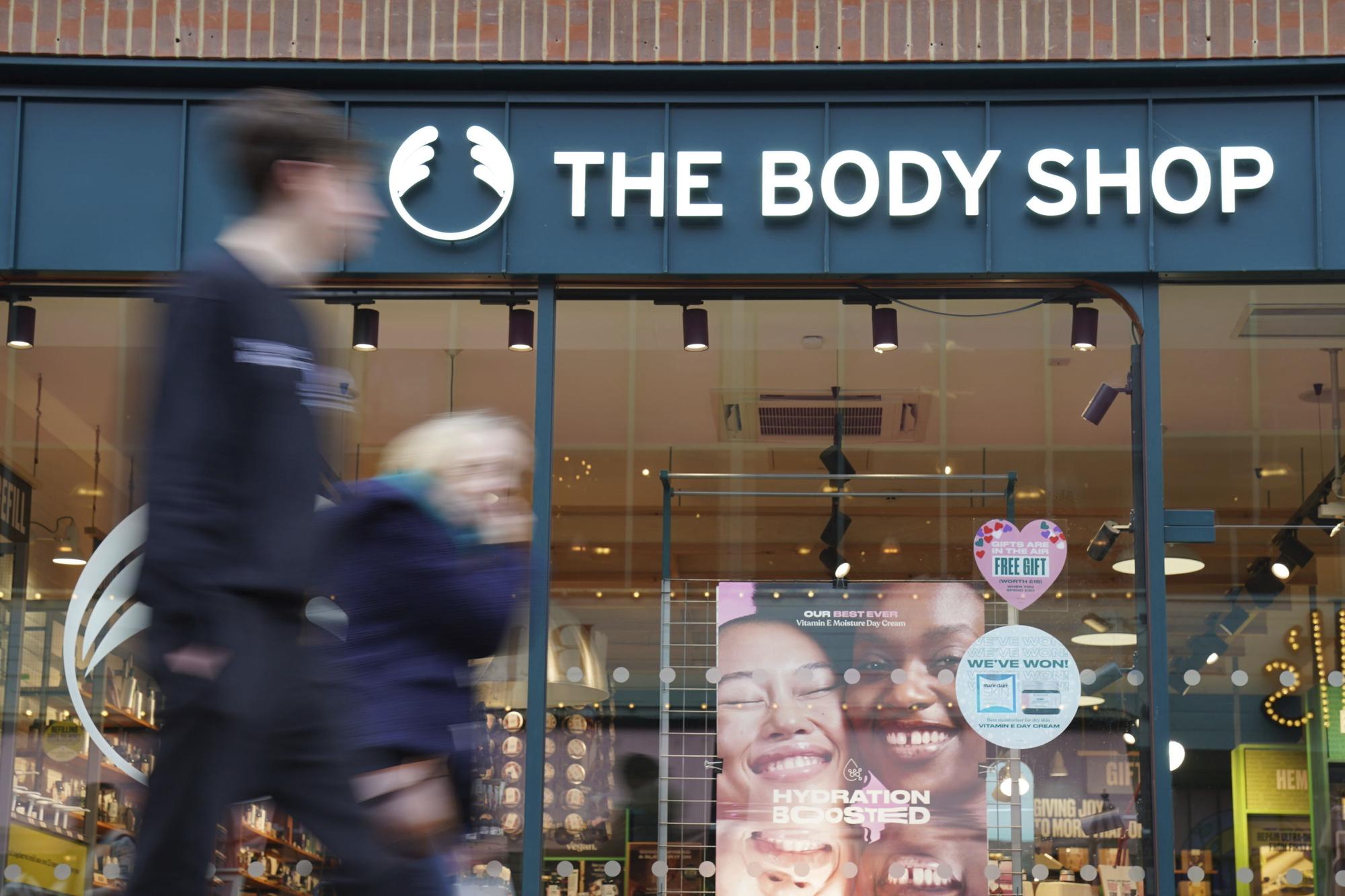 People walk past a Body Shop store in Canterbury, England, Tuesday, Feb. 13, 2024. The Body Shop, the British beauty and cosmetics retail chain, says it's appointed insolvency administrators after years of financial struggles. The retailer grew from a single shop in 1976 to become one of the most recognizable retailers on the British high street with hundreds of stores in the United Kingdom and beyond. (Gareth Fuller/PA via AP)