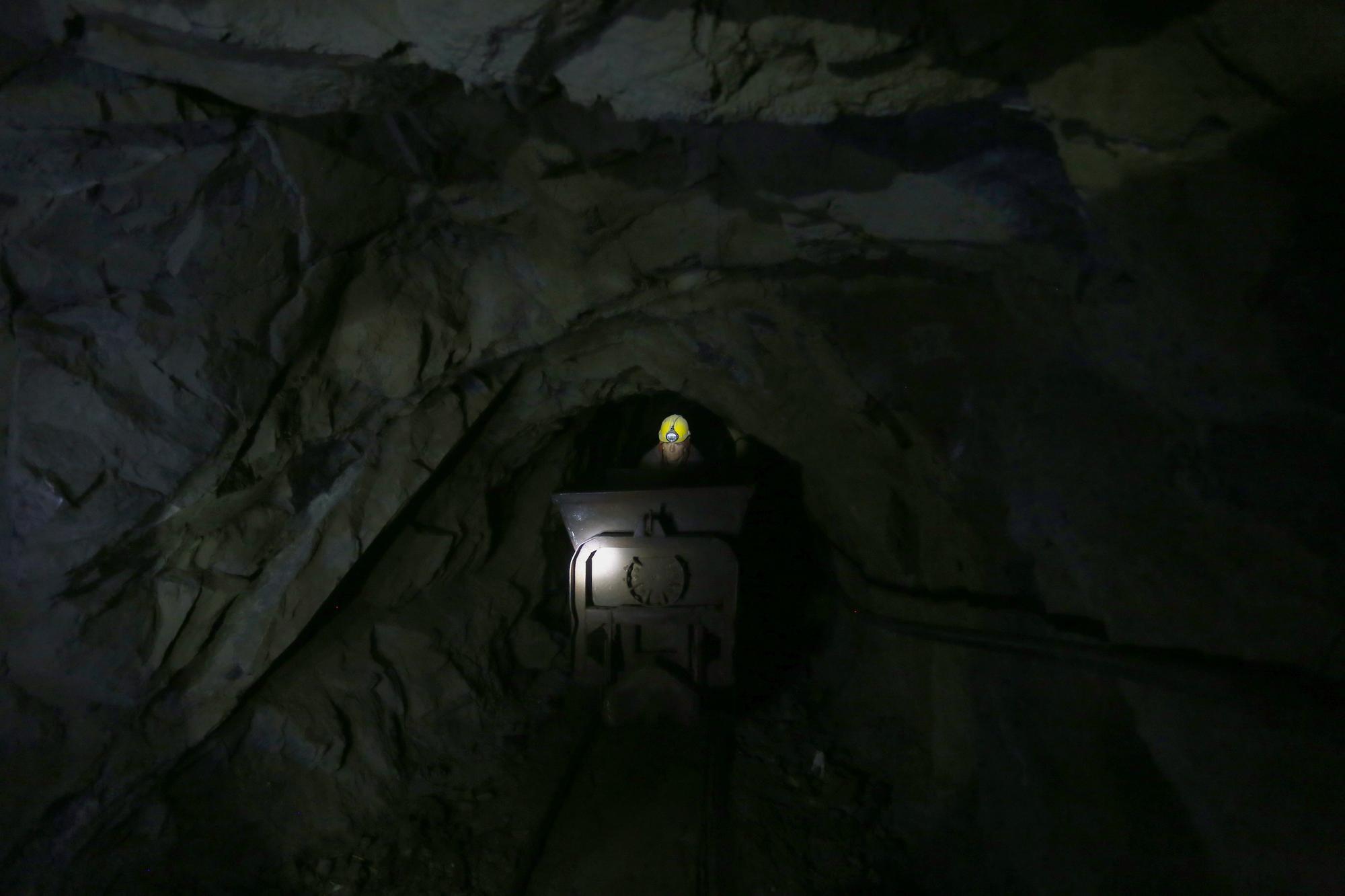 Miner Andon Murrja (52), pushes a cart inside a chromium mine in Bulqize on September 23, 2020. The chromium extraction industry is going through a difficult time due to a fall in the price of the ore in international markets and as a result of disruptions caused by the Covid-19 outbreak. As the pandemic rocks global commerce, knock-on effects are being felt in poor corners of the world like Albania, where chromium miners have nowhere to sell their goods due to a drop off in purchases from China. The Balkan country's chromium sector is entirely dependent on exports, leaving the men and women who extract it at the mercy of world prices. (Photo by Gent SHKULLAKU / AFP)
