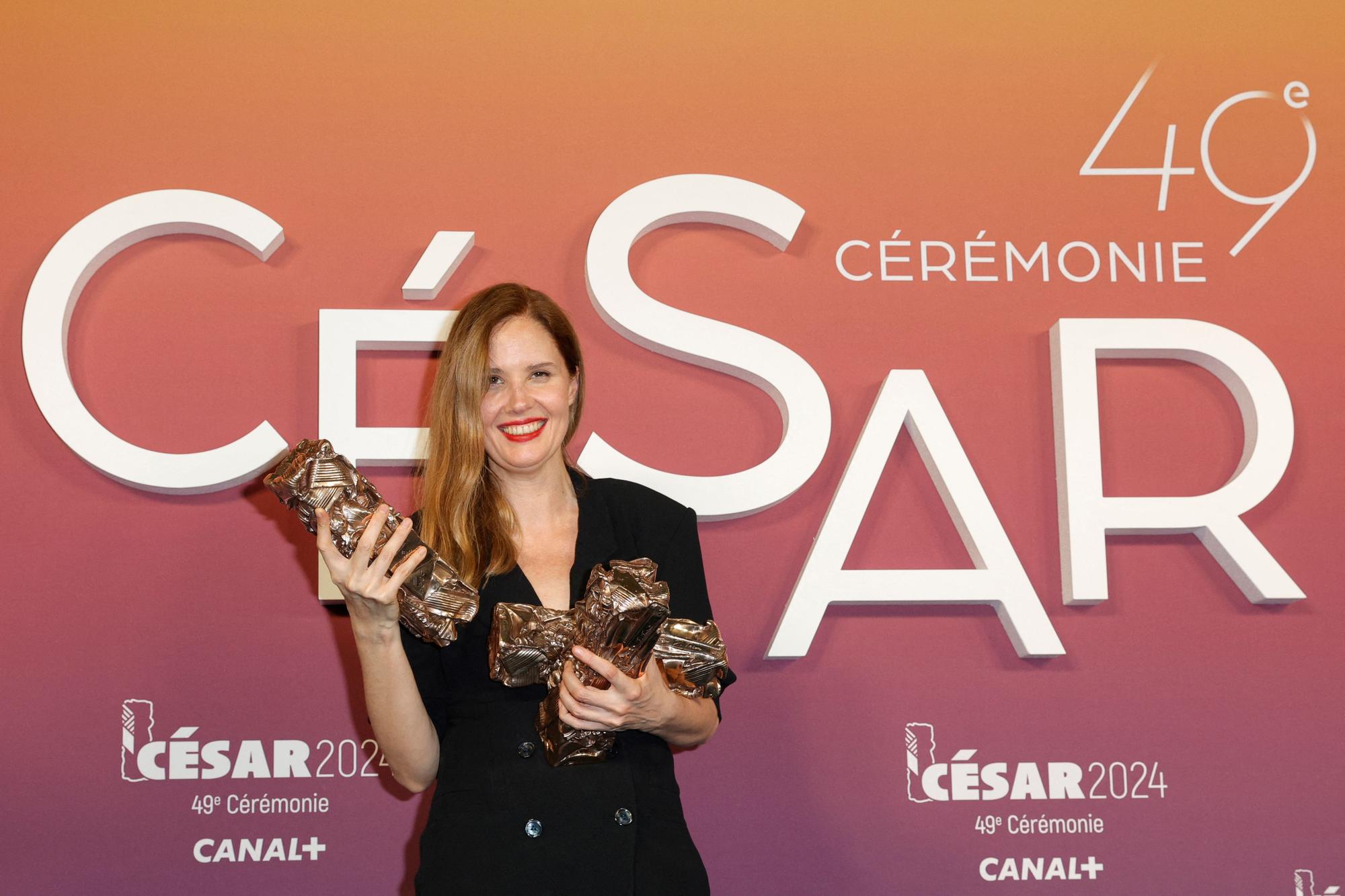 French film director and screenwriter Justine Triet poses with her trophies after winning the Best Directing award for the film "Anatomie d'une Chute" during the 49th edition of the Cesar Film Awards ceremony at the Olympia venue in Paris on February 23, 2024. (Photo by Geoffroy VAN DER HASSELT / AFP)