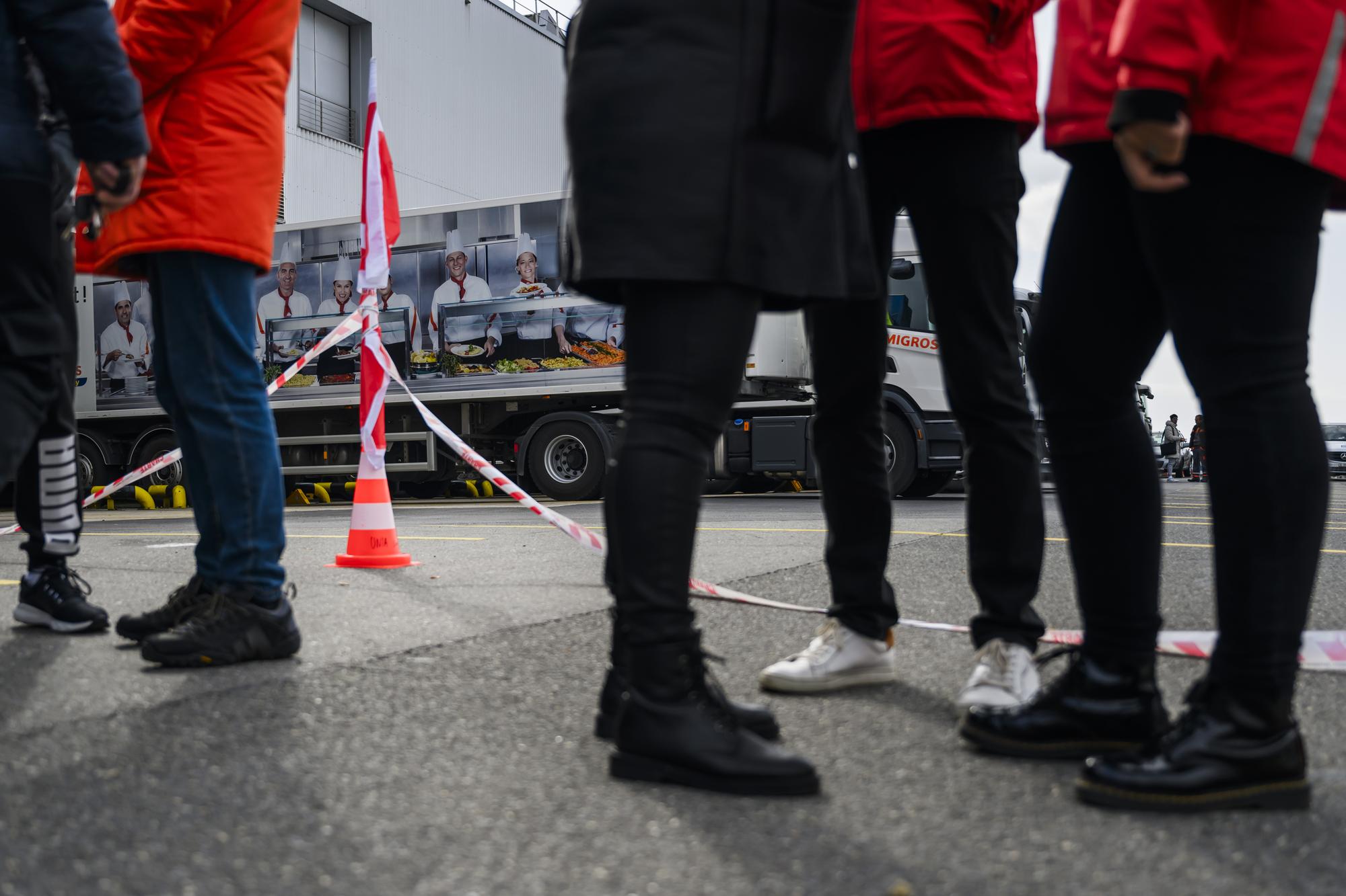 Un camion d'expedition de Migros Vaud arrive devant un quai de chargement pendant un rassemblement d'employes de Micarna, filiale du groupe Migros et de syndicalistes lors d'une journee de greve avec le syndicat Unia le jeudi 29 fevrier 2024 a Ecublens. Les employes de Micarna a Ecublens, dans le canton de Vaud, ont entame une greve pour protester contre la fermeture du site, annoncee pour le printemps 2025. Le syndicat Unia exige que la direction s'asseye a la table des negociations. (KEYSTONE/Jean-Christophe Bott)