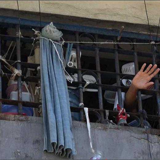 This screen grab taken from AFPTV shows a person waving his hand from a cell inside the main prison of Port-au-Prince, Haiti, on March 3, 2024, after a breakout by several thousand inmates. At least a dozen people died as gang members attacked the main prison in Haiti's capital, triggering a breakout by several thousand inmates, an AFP reporter and an NGO said on March 3. "We counted many prisoners' bodies," said Pierre Esperance of the National Network for Defense of Human Rights, adding that only around 100 of the National Penitentiary's estimated 3,800 inmates were still inside the facility after the gang assault overnight on March 2. (Photo by Luckenson JEAN / AFP)