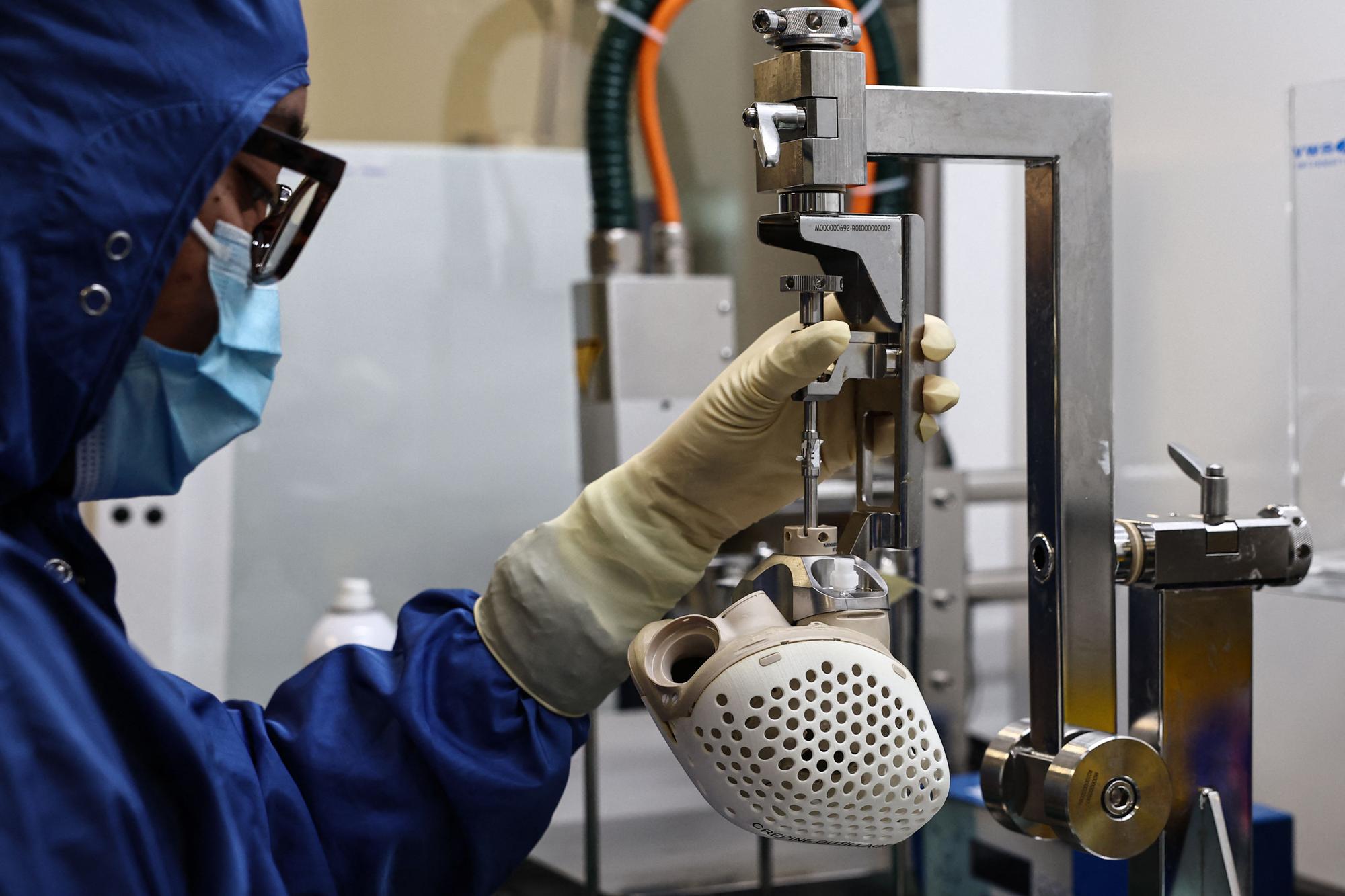 A Carmat employee works on an auto-regulating artificial heart, at the company's headquarters in Bois-d'Arcy, west of Paris, on January 16, 2024. (Photo by Anne-Christine POUJOULAT / AFP)